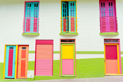 Exterior of typical residential building with bright colorful doors and windows on city street on sunny day in colombia