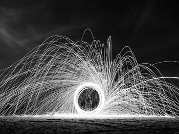 Person with wire wool against sky