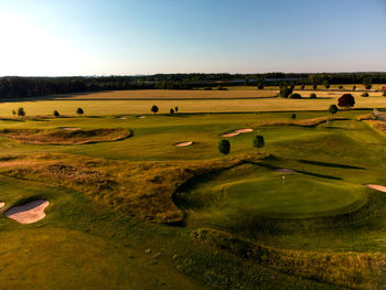 Scenic view of golf course against clear sky