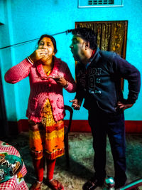 Full length of mother and girl standing in room