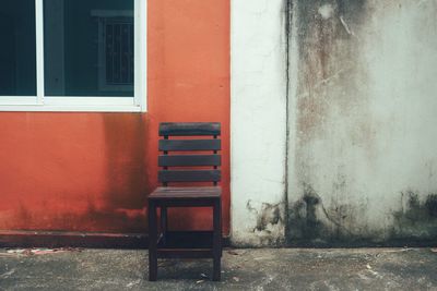 A wooden chair is placed in front of the wall.