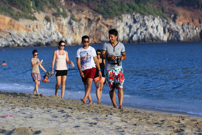 Rear view of people enjoying at beach