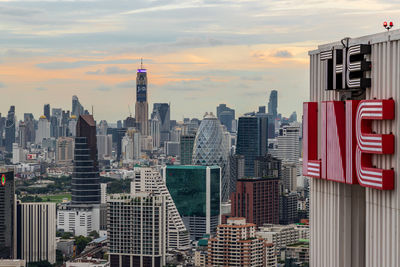 Modern buildings in city against cloudy sky