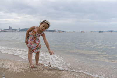 Rear view of woman standing at beach