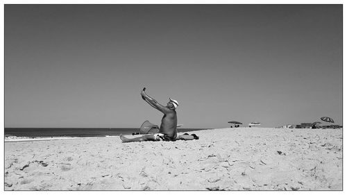 Rear view of man with umbrella on beach