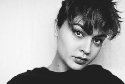 Close-up portrait of woman against gray background