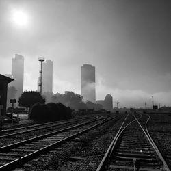 Railroad tracks in city against sky