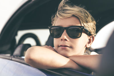 Boy wearing sunglasses sitting in car