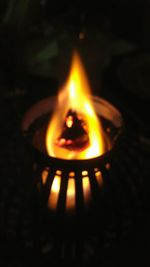 Close-up of lit candle in dark room