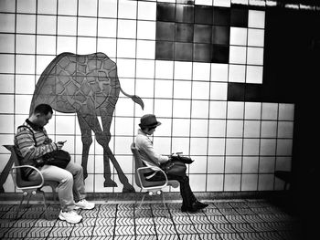 Men sitting on floor against wall