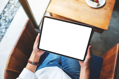 Midsection of woman using digital tablet