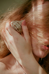 Close-up of woman with seashell