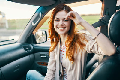 Portrait of happy woman sitting in car