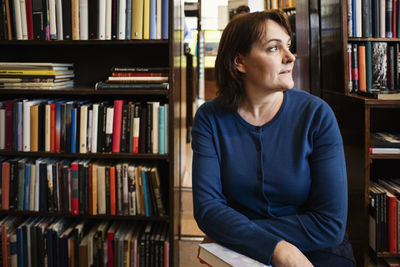 Thoughtful owner sitting in bookstore