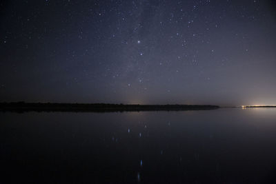 Scenic view of lake against sky at night