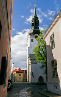 Houses by street in town against sky