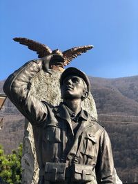 Low angle view of statue against clear blue sky