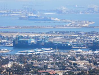 High angle view of city by sea against sky