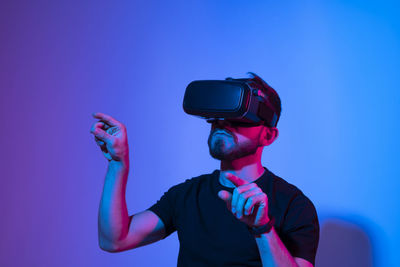 Young man wearing vr against colored background