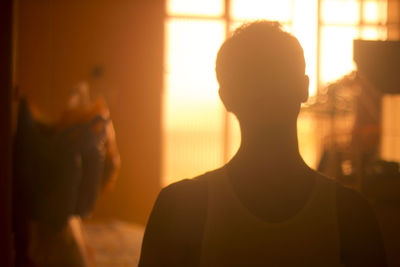 Close-up of man standing at home during sunset