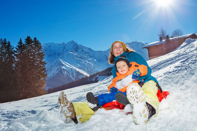 Portrait of woman sitting on snow covered mountain