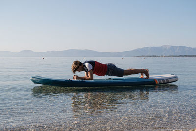 Man in boat on sea against clear sky