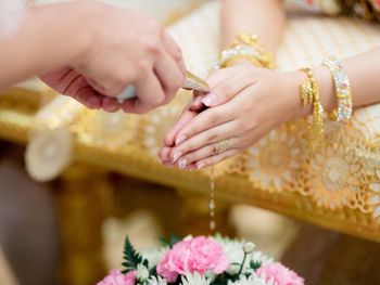 Woman sitting with hands clasped during wedding ceremony