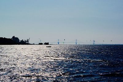Sailboats on sea against clear sky