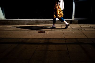 Low section of woman walking on street