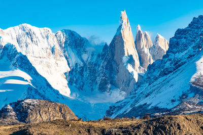 Panoramic view of snowcapped mountains against blue sky