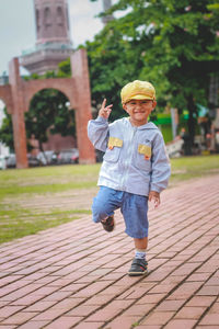 Full length portrait of boy standing on footpath