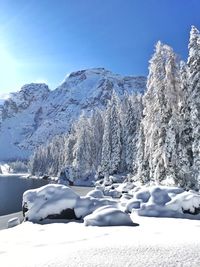 Snow covered landscape against sky during winter
