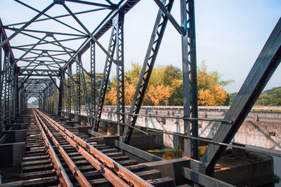 Railroad tracks by bridge against clear sky