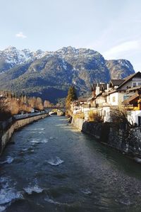 Scenic view of river by mountains against sky