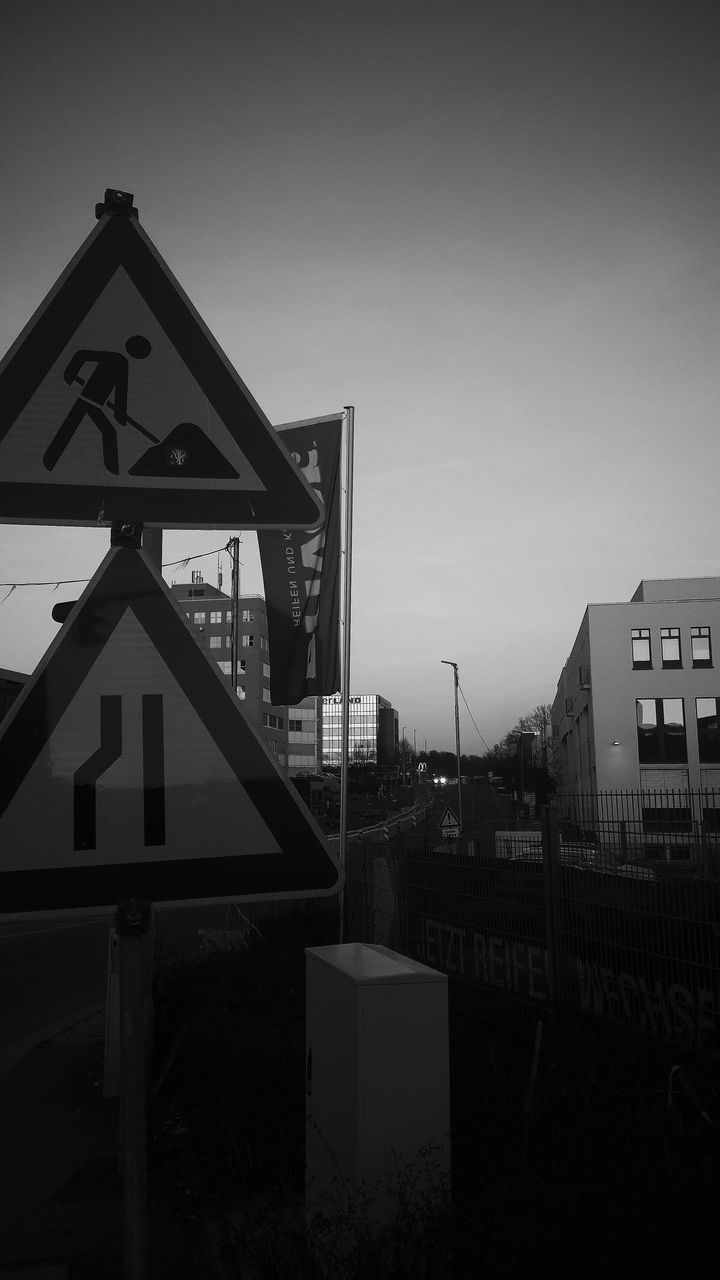 ROAD SIGN BY BUILDING AGAINST SKY