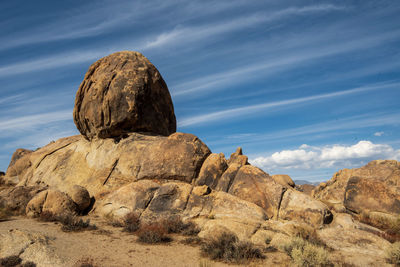 Boulders in desert landscape with layered clouds