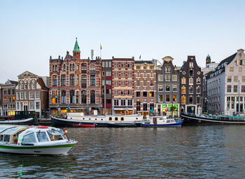 Boats in canal against clear sky