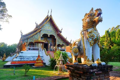 Statue of temple against building and sky