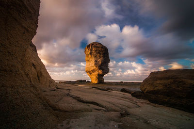 Scenic view of rocks against cloudy sky