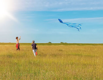 Rear view of woman standing on field