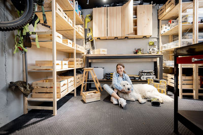 Portrait of young woman sitting on shelf