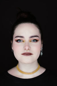 Portrait of woman against black background