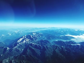 Aerial view of dramatic landscape against blue sky