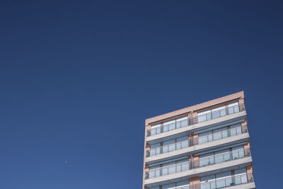 Low angle view of modern building against clear blue sky