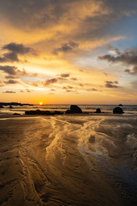 Scenic view of beach against sky during sunset