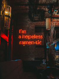 Information sign on illuminated restaurant at night