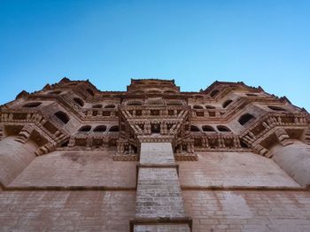 Low angle view of old building against clear blue sky