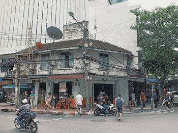 People on street against buildings in city