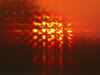 Defocused image of illuminated lights against orange background