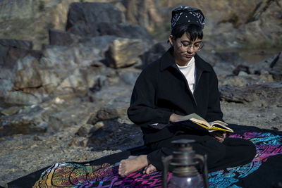 Full length of young woman standing on rock
